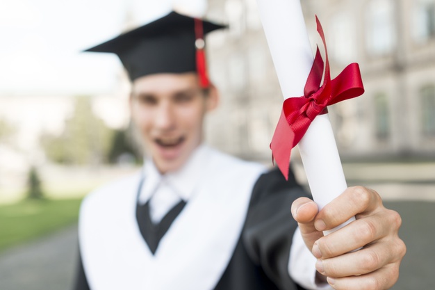 Homem com um diploma na mão.