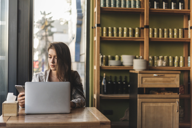 Mulher trabalhando no computador em um restaurante